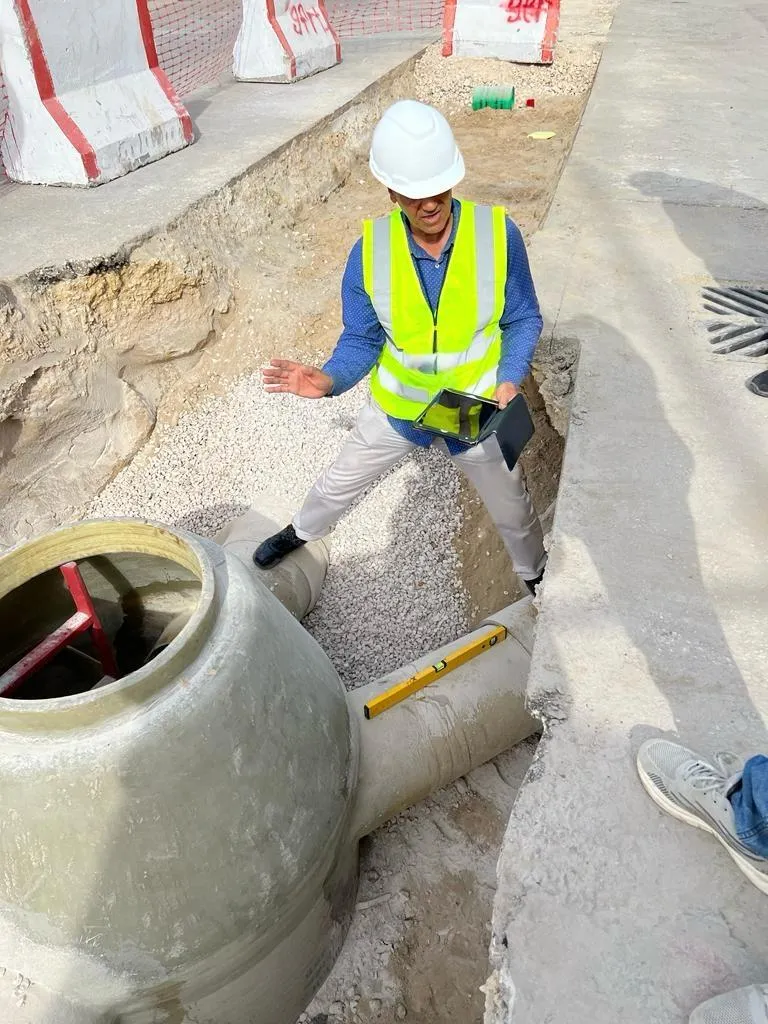 Worker inspecting a pipe with a tablet