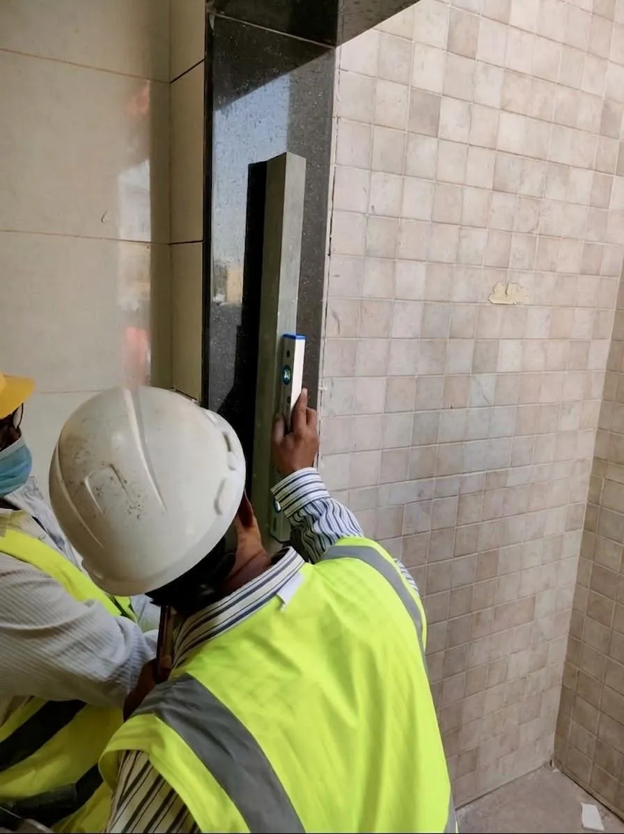 Worker checking tiles beside a doorway