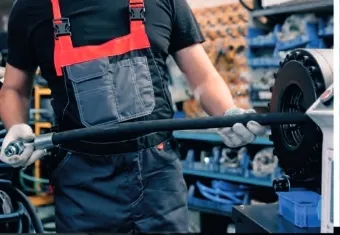 Worker assembling a hose at a workbench