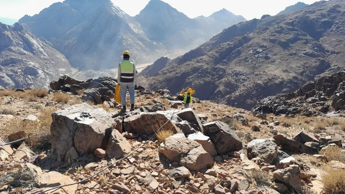 Survey worker among rocks in a mountain landscape