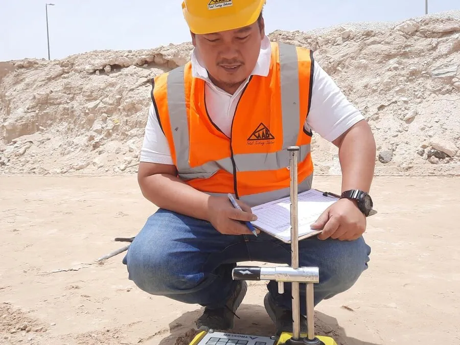Worker using a field testing instrument on soil