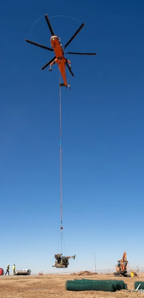 Helicopter airlifting geotechnical drilling rig to remote exploration site